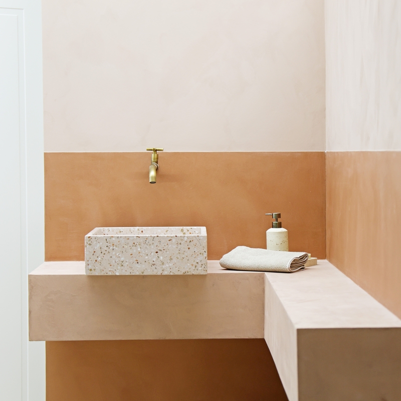 Beton-Ciré-Wand in Terrakotta mit Terrazzo-Waschbecken