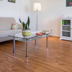 Rot brauner Vinylboden in Holzoptik in einem Wohnzimmer mit beiger Couch und einem Glastisch