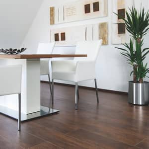 Dunkelbrauner Vinylboden in Holzoptik in einem Esszimmer mit weißem Tisch