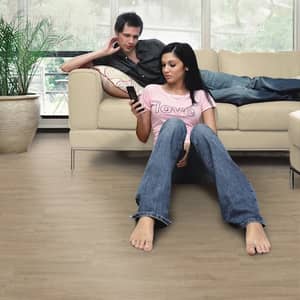 Grau brauner Vinylboden in einem Wohnzimmer mit zwei Personen auf einer beigen Couch