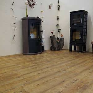 Heller Vinylboden in Holzoptik in einem Wohnzimmer mit einem Kamin und einem Holzstamm in der Ecke